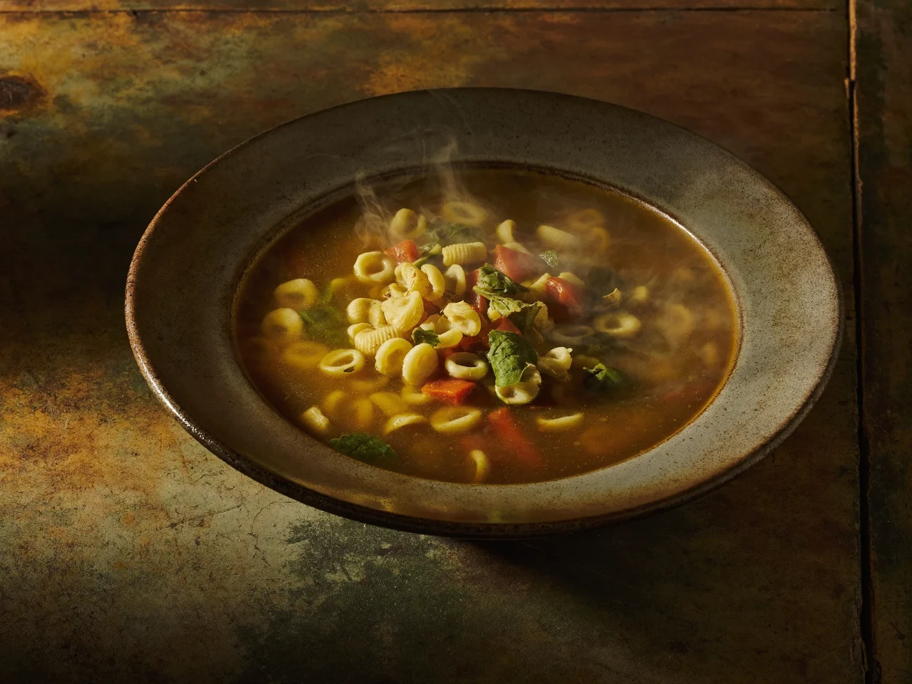 Minestra morbida di verdure con pasta piccola in una ciotola di ceramica